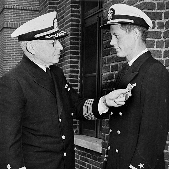 photo of President Kennedy being awarded the Navy and Marine Corps Medal on June 11 1944